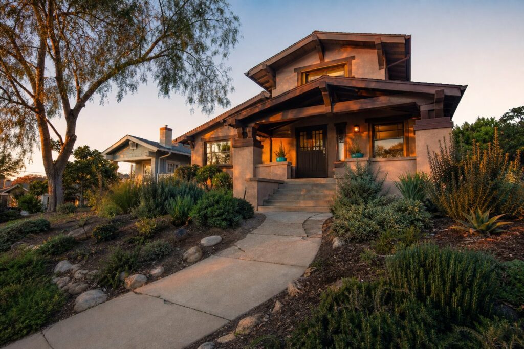 Single-family Craftsman home on elevated Encanto lot with mature pepper tree, native landscaping, and natural afternoon light in San Diego.